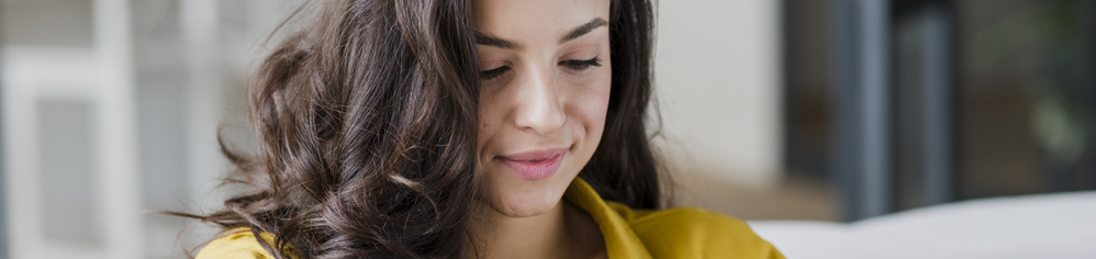 Mujer joven consultando en su teléfono móvil información sobre el VPH